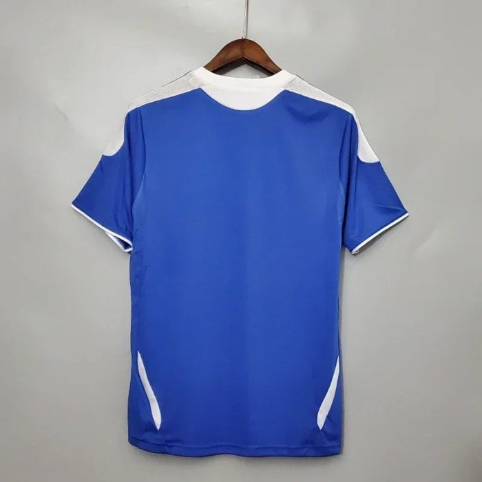 Camiseta de fútbol retro azul con detalles blancos, vista trasera en percha